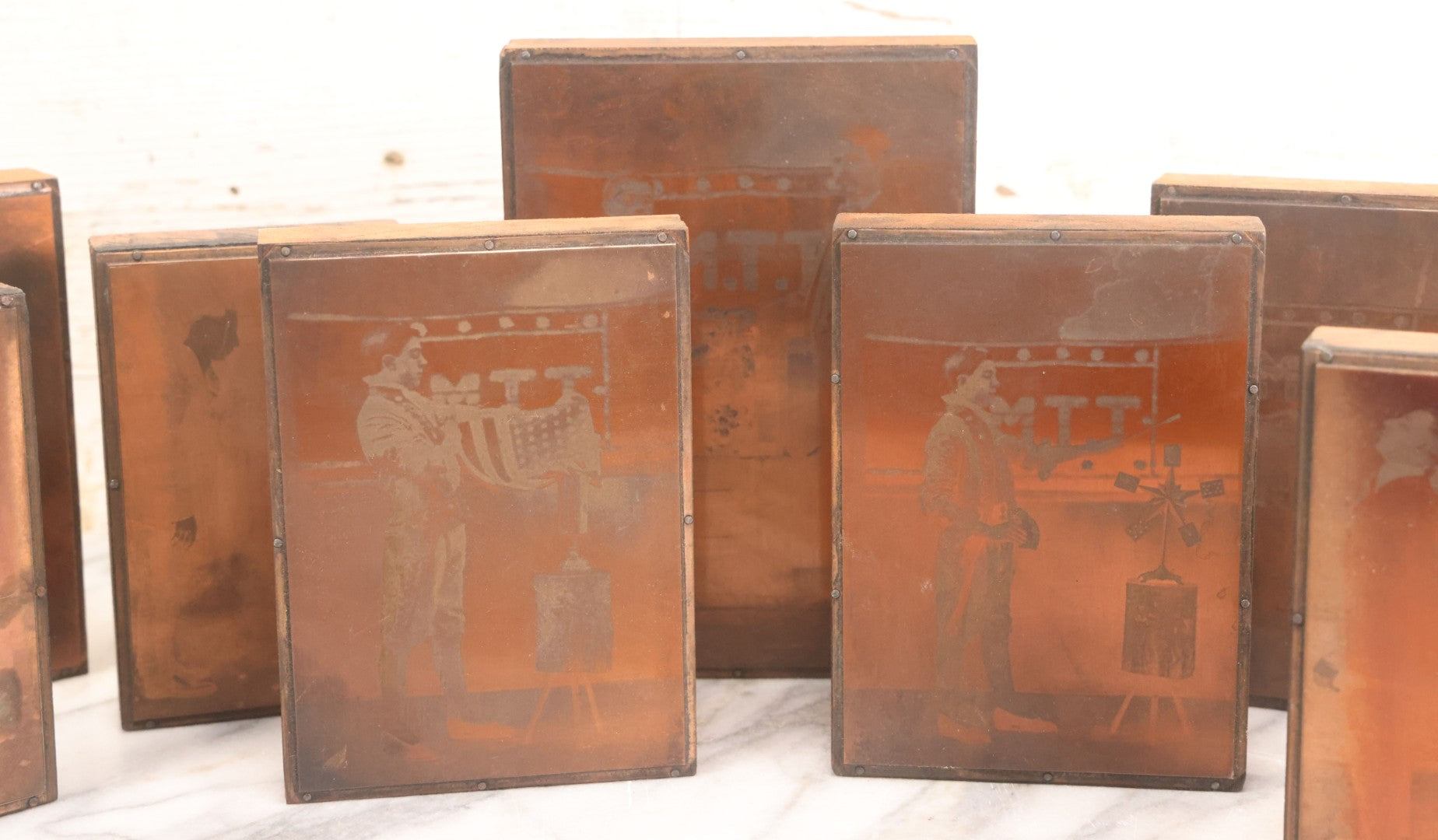 Lot 036 - Grouping Of Ten Vintage Photo Printing Blocks Showing A Magician Engaged In Various Magic Tricks, Magician's Banner Visible, "M.T.T.," Various Tricks Incl. Ring Trick, Flag Trick, And More