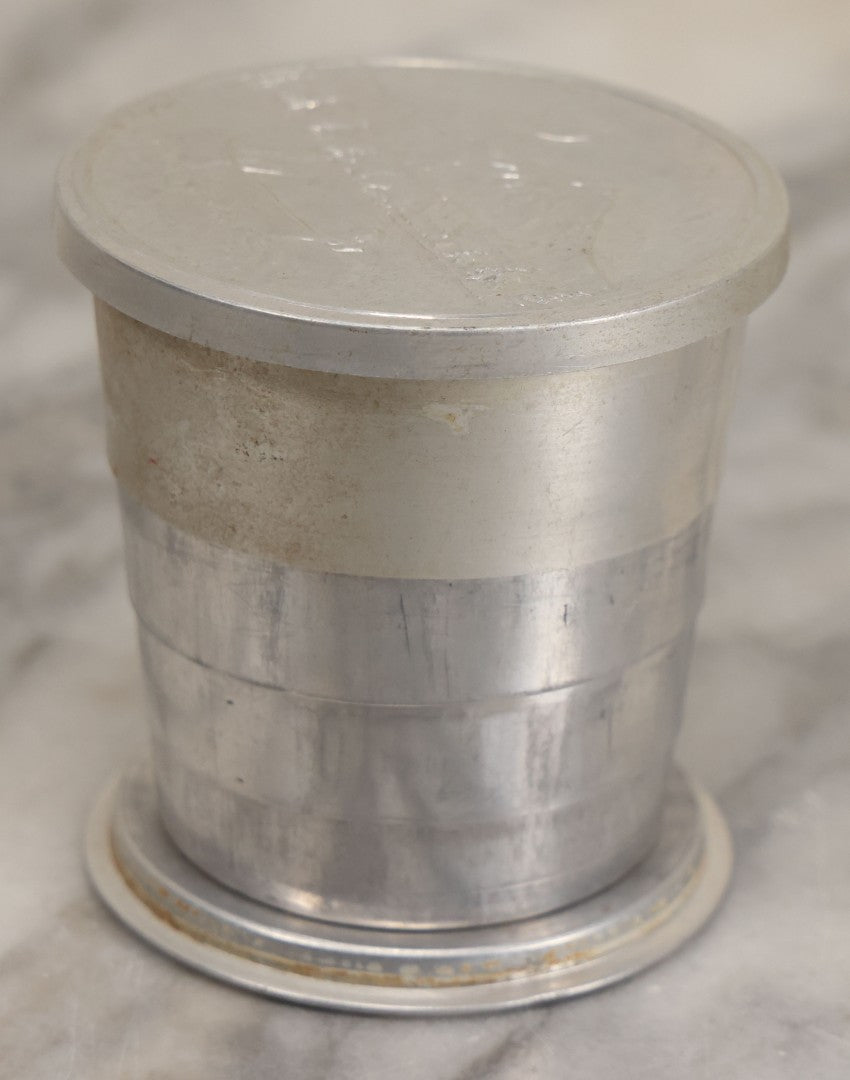 Lot 048 - Vintage Collapsible Camping Tin Cup With Embossed Lid With Children Canoeing In Front Of Mountain At Night