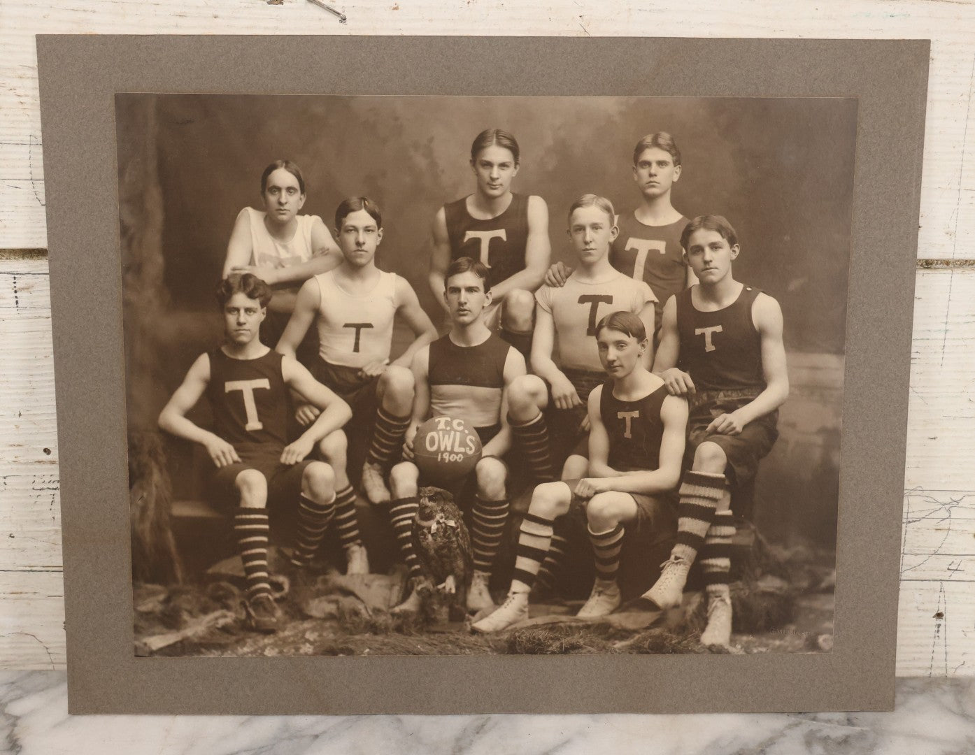 Lot 078 - Antique Boarded Photograph Of High School Basketball Team, The T.C. Owls, Posing With Owl Mascot, In Handmade Jerseys, 1900, F. Gutekunst, Photographer, Philadelphia, Pennsylvania