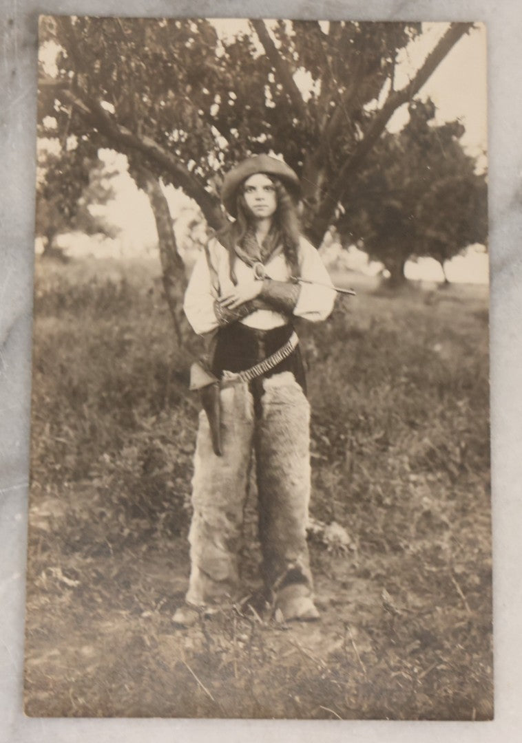 Lot 083 - Pair Of Antique Real Photo Postcards R.P.P.C. Of A Gun Slingin' Cowgirl Holding A Revolver, Dated August 1912 On Verso, And Kind Looking Farm Boy In Coveralls And Cowboy Hat Smoking