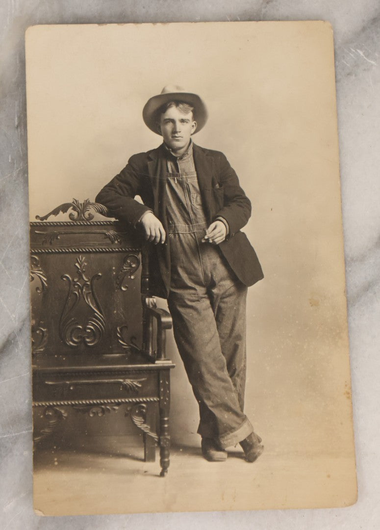 Lot 083 - Pair Of Antique Real Photo Postcards R.P.P.C. Of A Gun Slingin' Cowgirl Holding A Revolver, Dated August 1912 On Verso, And Kind Looking Farm Boy In Coveralls And Cowboy Hat Smoking