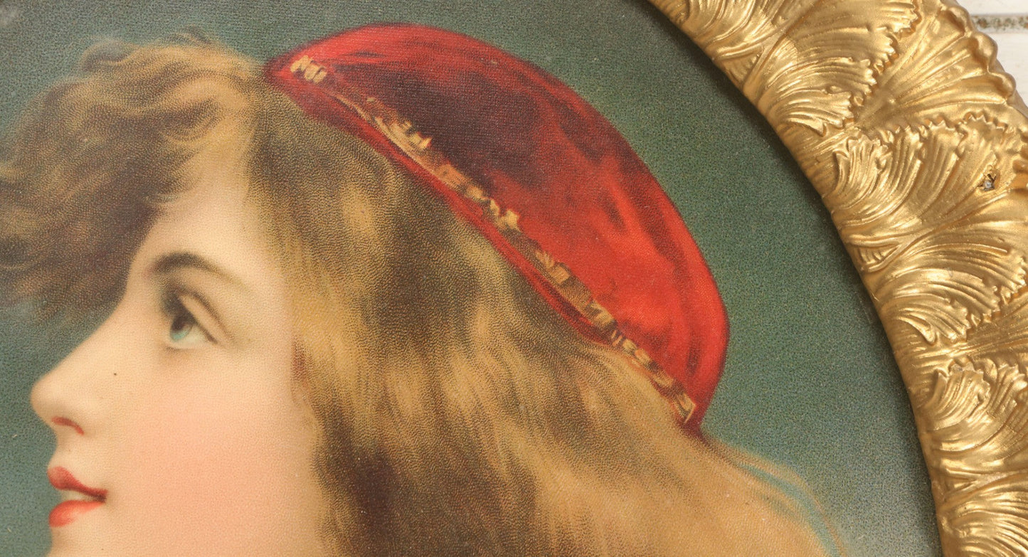 Lot 006 - Antique Chromolithograph Portrait Print Of Blue-Eyed Brunette Beauty With Red Velvet Cap And Loose Fitting Red Gown In Ornate Gilded Molded Gesso Oval Frame, 21" x 25"