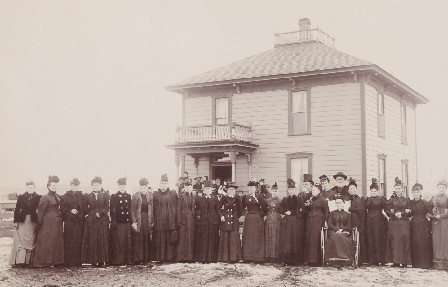 Lot 140 - Antique Boarded Photograph Of Group Of Women In Dark Attire Posing Outside Two Story Home, Including Men In Top Hats And Woman In Wheelchair, Photographed By U.H. Henry, Prescott, Washington