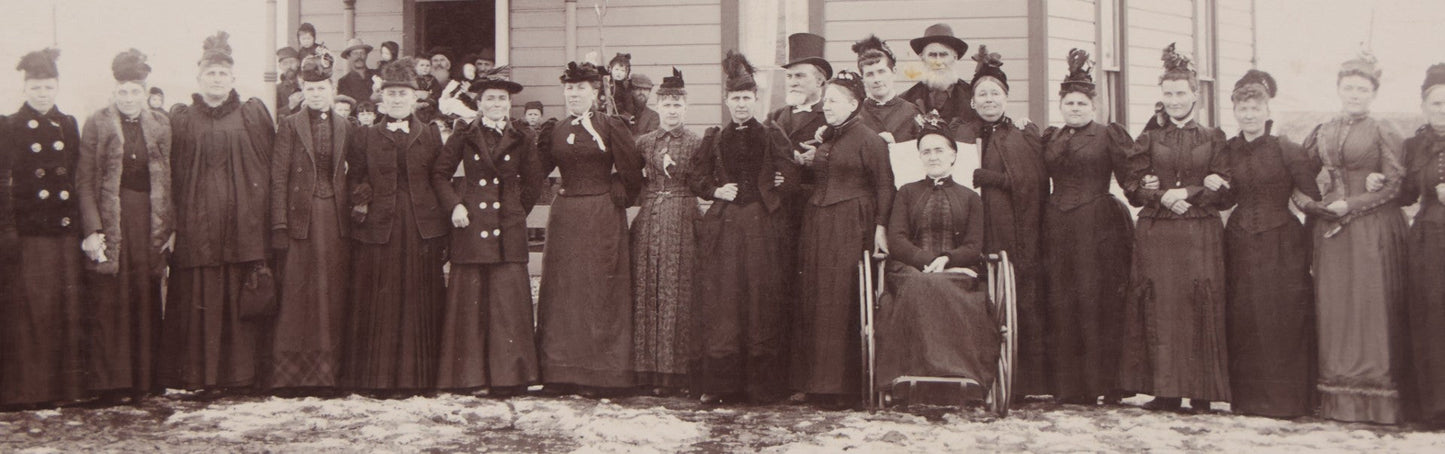Lot 140 - Antique Boarded Photograph Of Group Of Women In Dark Attire Posing Outside Two Story Home, Including Men In Top Hats And Woman In Wheelchair, Photographed By U.H. Henry, Prescott, Washington