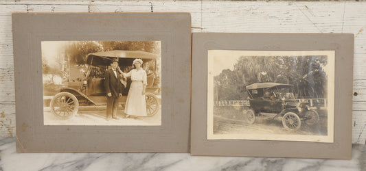 Lot 141 - Pair Of Antique Boarded Photographs Including Man And Woman Couple Posing Beside Early Automobile, Woman Does Not Look Thrilled And Man Seems To Know It, And Man Driving Away Without Her