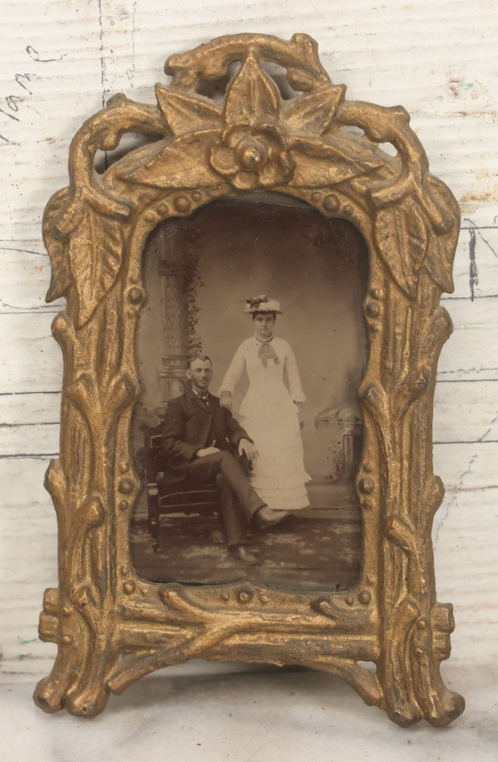 Lot 015 - Antique Tintype Photograph Of A Man And Woman Couple In Gold Painted Cast Iron Branch Frame With Flower Motif, Wire Hanger, 3-1/2" x 5-7/8"