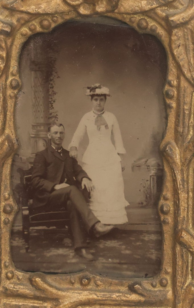 Lot 015 - Antique Tintype Photograph Of A Man And Woman Couple In Gold Painted Cast Iron Branch Frame With Flower Motif, Wire Hanger, 3-1/2" x 5-7/8"