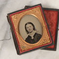 Lot 016 - Antique 1/9th Plate Ruby Ambrotype Photograph Of A Pretty Young Woman With Braided Hair, A Large Brooch, A Large Bow, And Tinted Lips, In Full Split Leatherette Union Case, C.F. Lamb, Photographer, Fitchburg, Massachusetts