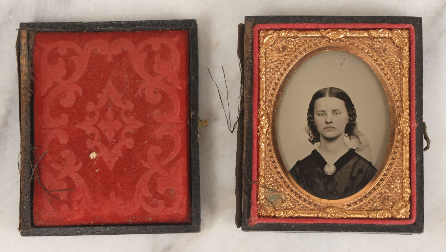 Lot 016 - Antique 1/9th Plate Ruby Ambrotype Photograph Of A Pretty Young Woman With Braided Hair, A Large Brooch, A Large Bow, And Tinted Lips, In Full Split Leatherette Union Case, C.F. Lamb, Photographer, Fitchburg, Massachusetts