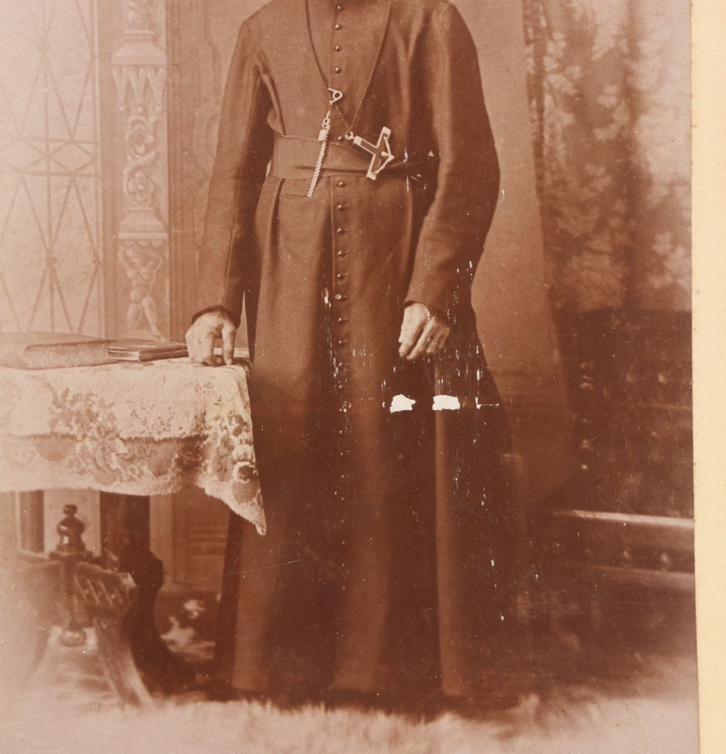 Lot 019 - Antique Cabinet Card Photograph Of A Bearded Priest In Black Robe With Large Pectoral Crucifix Tucked In Belt, Frank Lariviere, Photographer, Central Falls & Pawtucket, Rhode Island