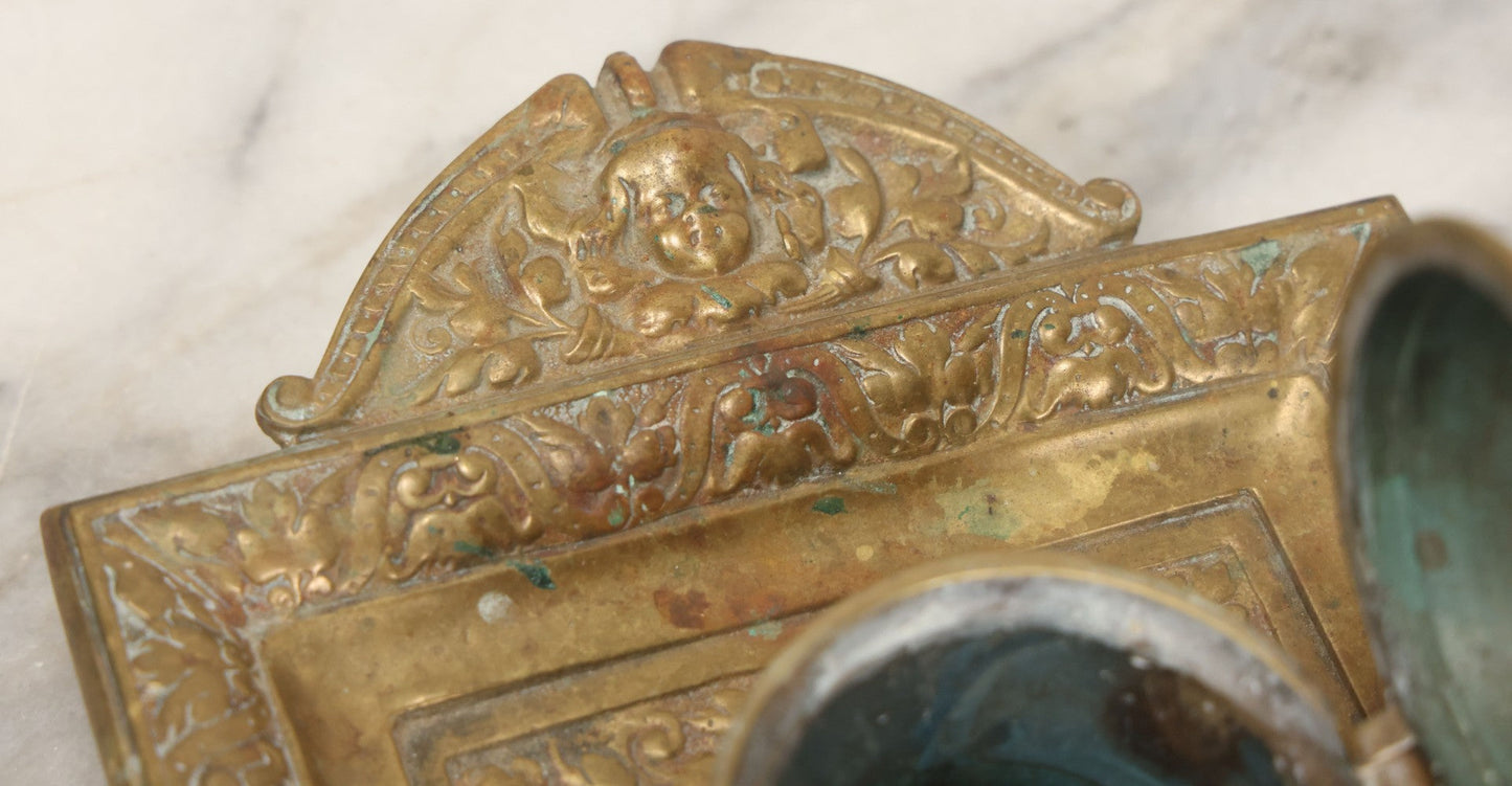Lot 027 - Antique Cast Brass Double Inkwell And Desk Tray With Cherub And Green Man Motifs, Hinged Lids, Underside Marked 3143, No Inserts