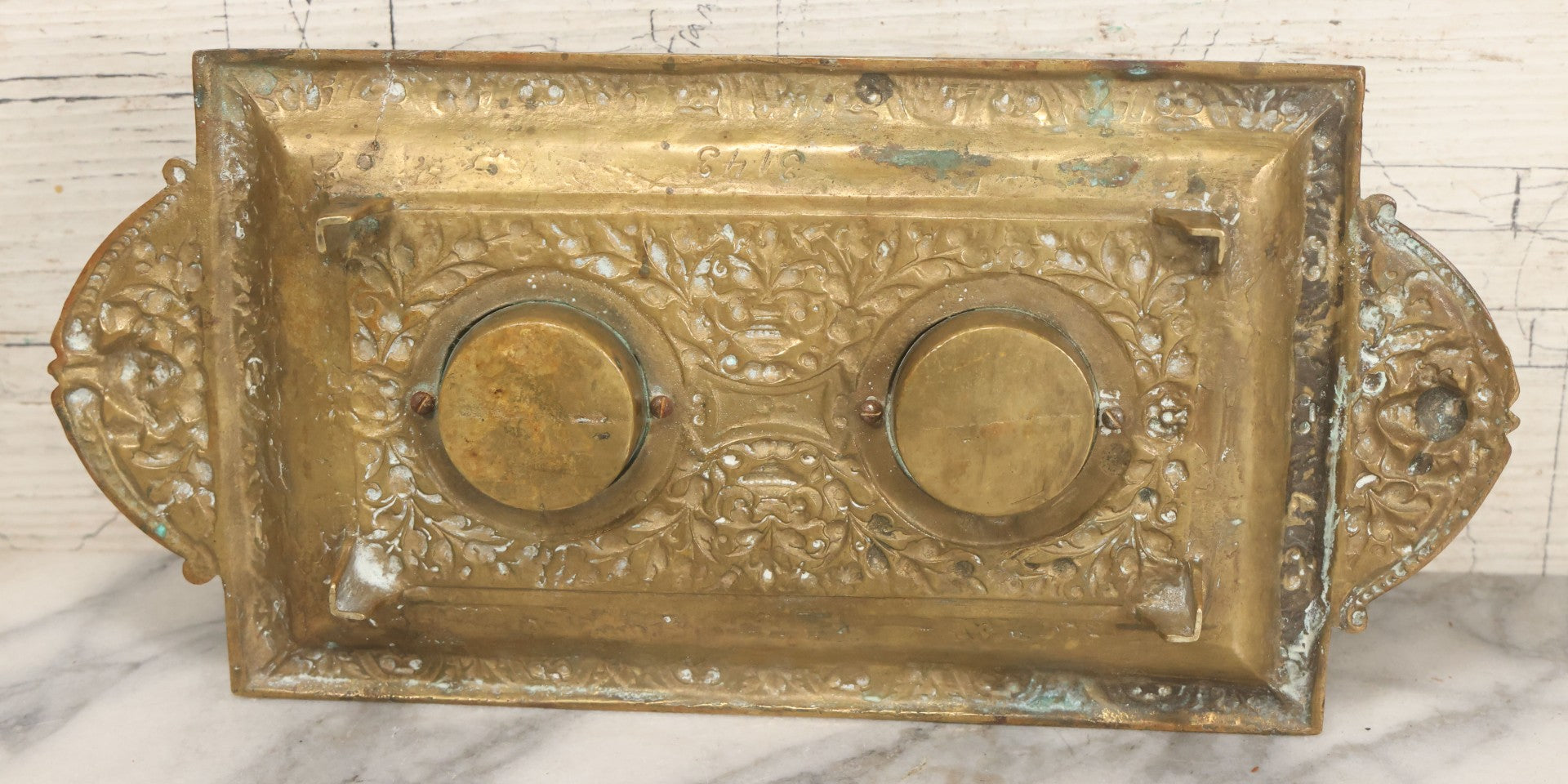 Lot 027 - Antique Cast Brass Double Inkwell And Desk Tray With Cherub And Green Man Motifs, Hinged Lids, Underside Marked 3143, No Inserts