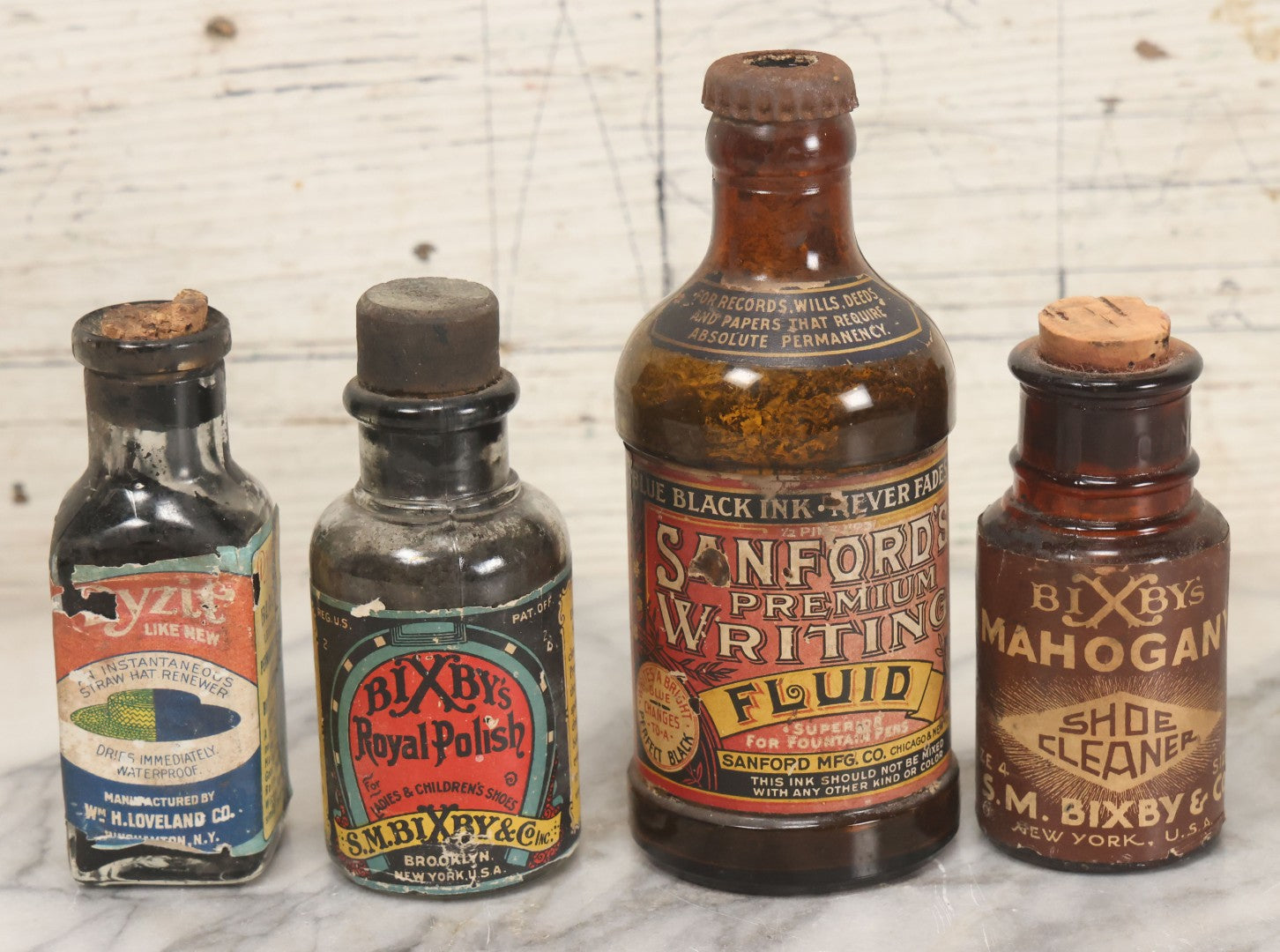 Lot 040 - Grouping Of Four Vintage Ink And Polish Glass Bottles With Paper Labels Including Dyzit Straw Hat Renewer, Sanford's Premium Writing Fluid, Bixby Mahogany Shoe Cleaner, And Bixby Royal Shoe Polish