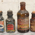 Lot 040 - Grouping Of Four Vintage Ink And Polish Glass Bottles With Paper Labels Including Dyzit Straw Hat Renewer, Sanford's Premium Writing Fluid, Bixby Mahogany Shoe Cleaner, And Bixby Royal Shoe Polish