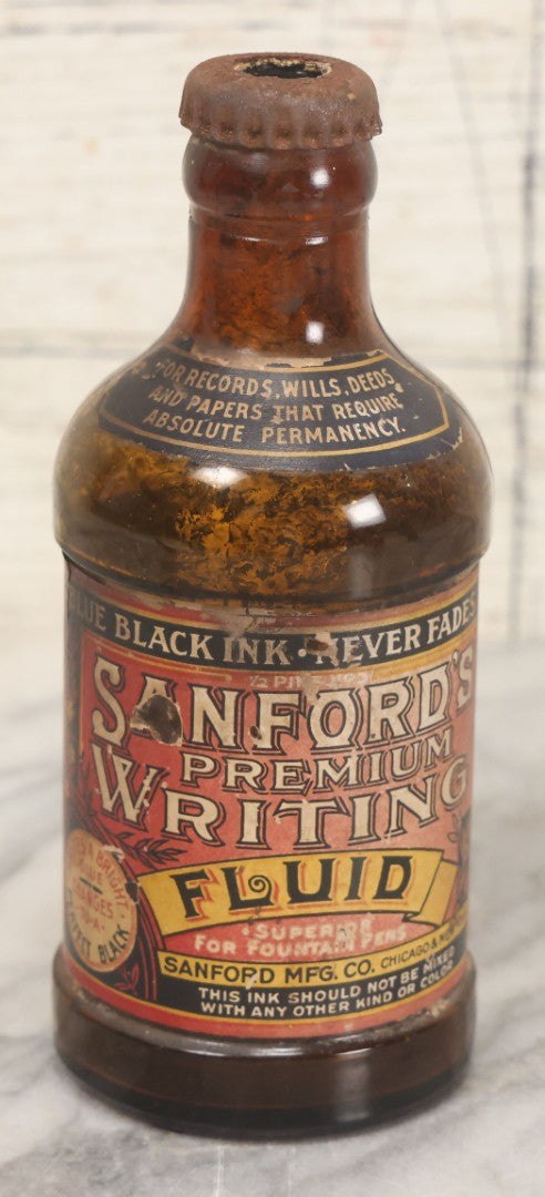 Lot 040 - Grouping Of Four Vintage Ink And Polish Glass Bottles With Paper Labels Including Dyzit Straw Hat Renewer, Sanford's Premium Writing Fluid, Bixby Mahogany Shoe Cleaner, And Bixby Royal Shoe Polish