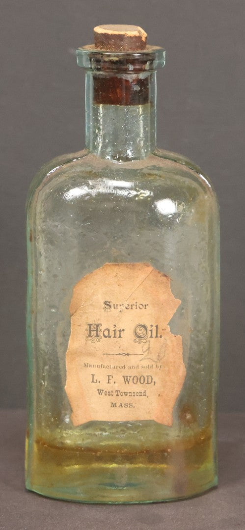 Lot 042 - Antique Superior Hair Oil Clear Glass Bottle With Cork And Remnants Of Contents, Paper Label, Manufactured And Sold By L.F. Wood, West Townsend, Massachusetts, 5-1/4" Height