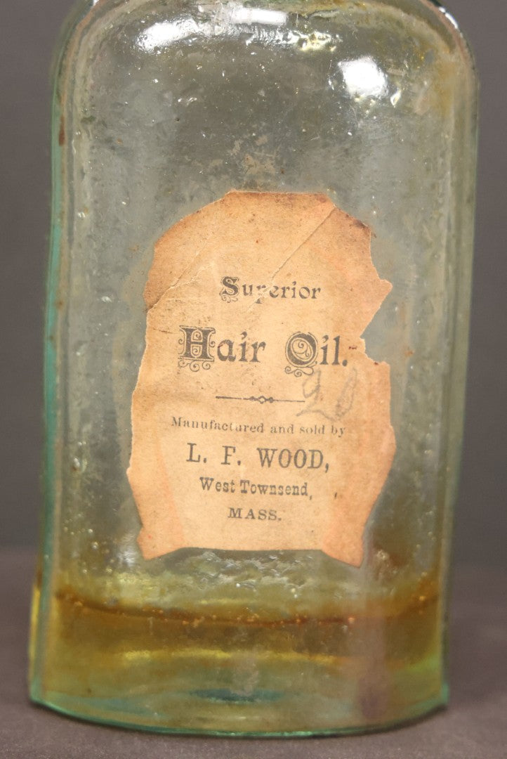 Lot 042 - Antique Superior Hair Oil Clear Glass Bottle With Cork And Remnants Of Contents, Paper Label, Manufactured And Sold By L.F. Wood, West Townsend, Massachusetts, 5-1/4" Height