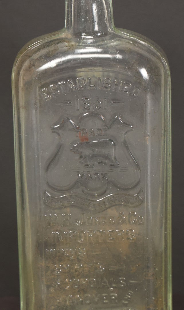 Lot 046 - Antique W.H. Jones & Co. Clear Glass Bottle With Bear Motif Trade Mark, Importers Of Wines, Spirits, And Cordials, Boston, Massachusetts, 8-3/8" Height