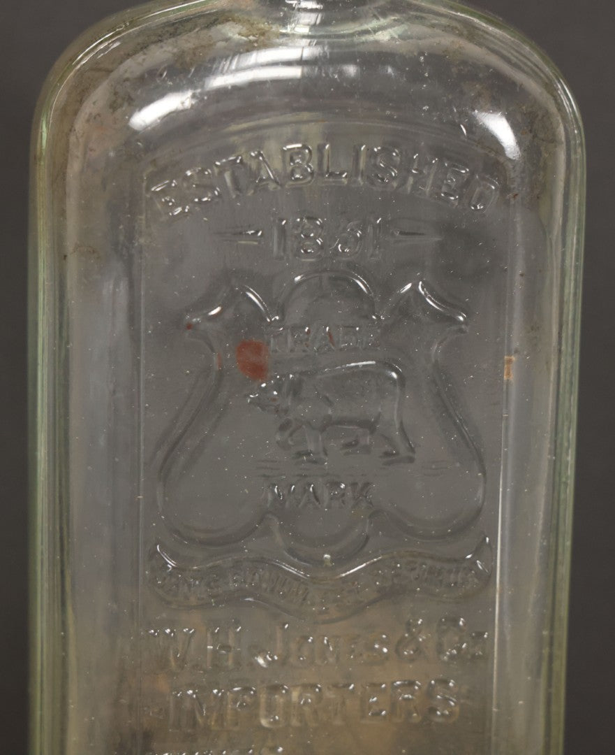 Lot 046 - Antique W.H. Jones & Co. Clear Glass Bottle With Bear Motif Trade Mark, Importers Of Wines, Spirits, And Cordials, Boston, Massachusetts, 8-3/8" Height