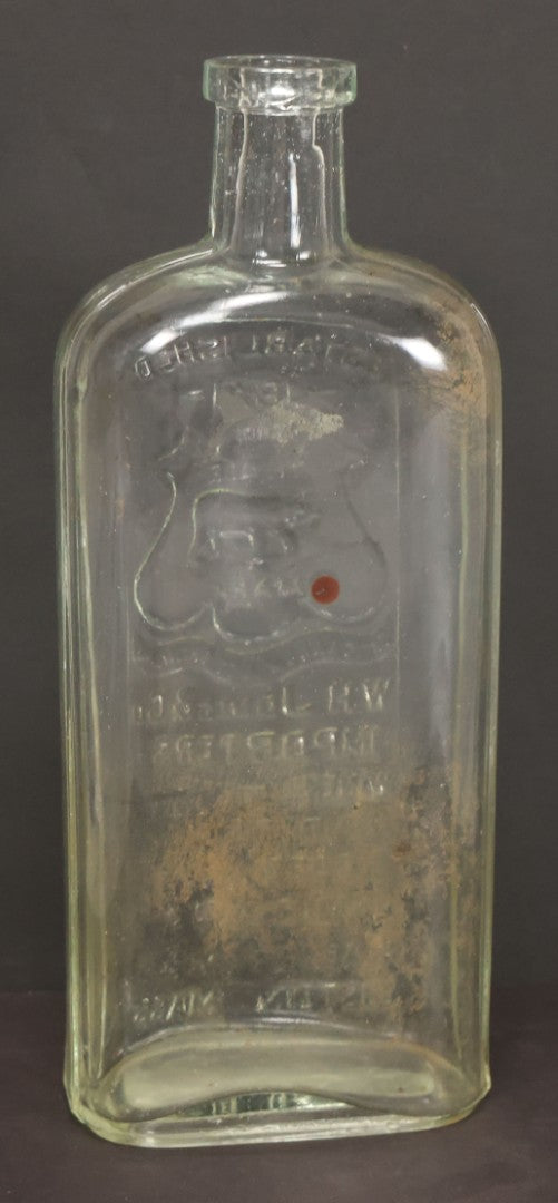 Lot 046 - Antique W.H. Jones & Co. Clear Glass Bottle With Bear Motif Trade Mark, Importers Of Wines, Spirits, And Cordials, Boston, Massachusetts, 8-3/8" Height