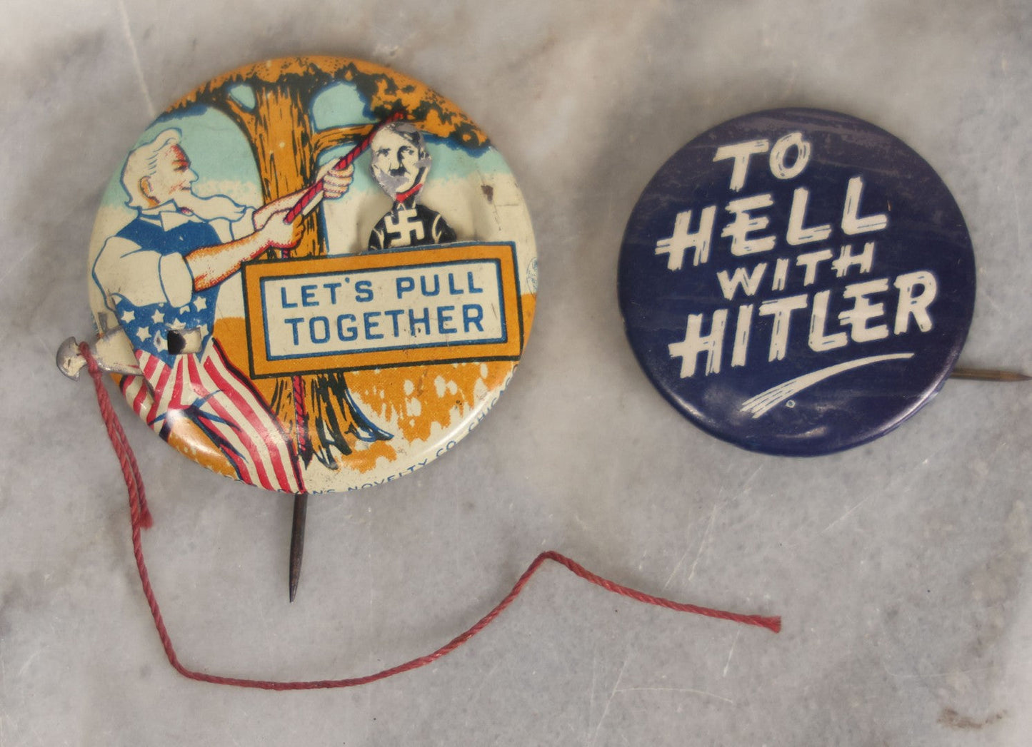 Lot 008 - Pair Of Vintage World War 2 Era Anti Hitler Pinback Buttons Including Animated Button Of Uncle Sam Hanging Hitler "Let's Pull Together," And "To Hell With Hitler" Blue Button