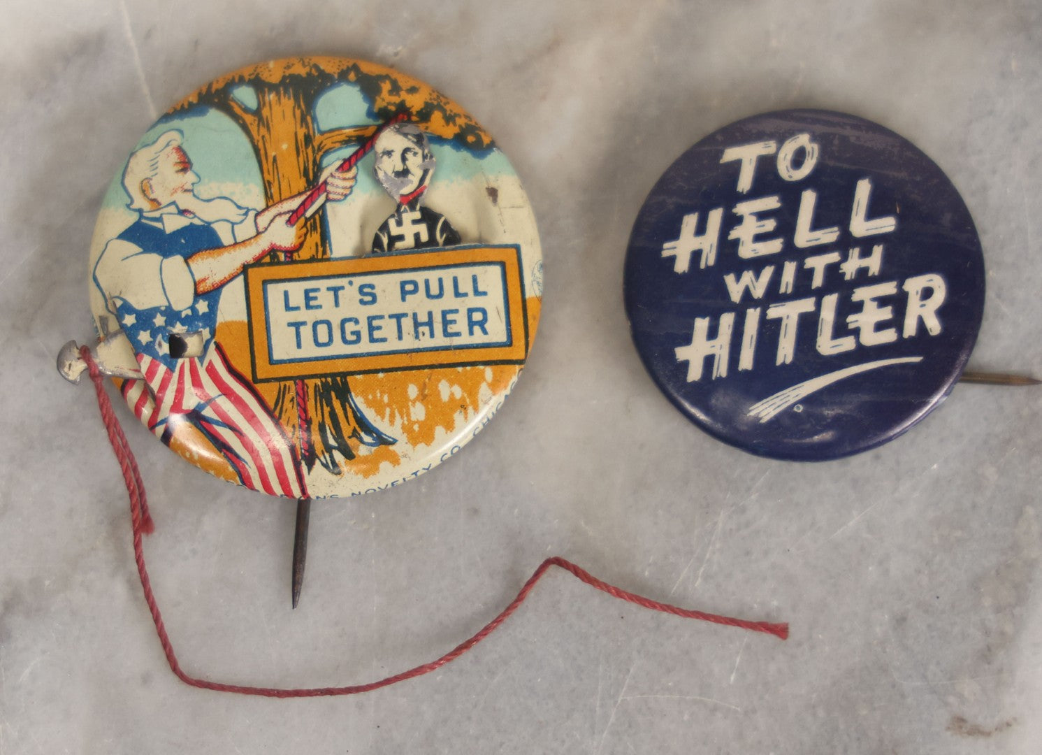 Lot 008 - Pair Of Vintage World War 2 Era Anti Hitler Pinback Buttons Including Animated Button Of Uncle Sam Hanging Hitler "Let's Pull Together," And "To Hell With Hitler" Blue Button