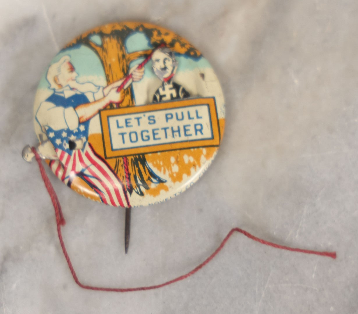 Lot 008 - Pair Of Vintage World War 2 Era Anti Hitler Pinback Buttons Including Animated Button Of Uncle Sam Hanging Hitler "Let's Pull Together," And "To Hell With Hitler" Blue Button