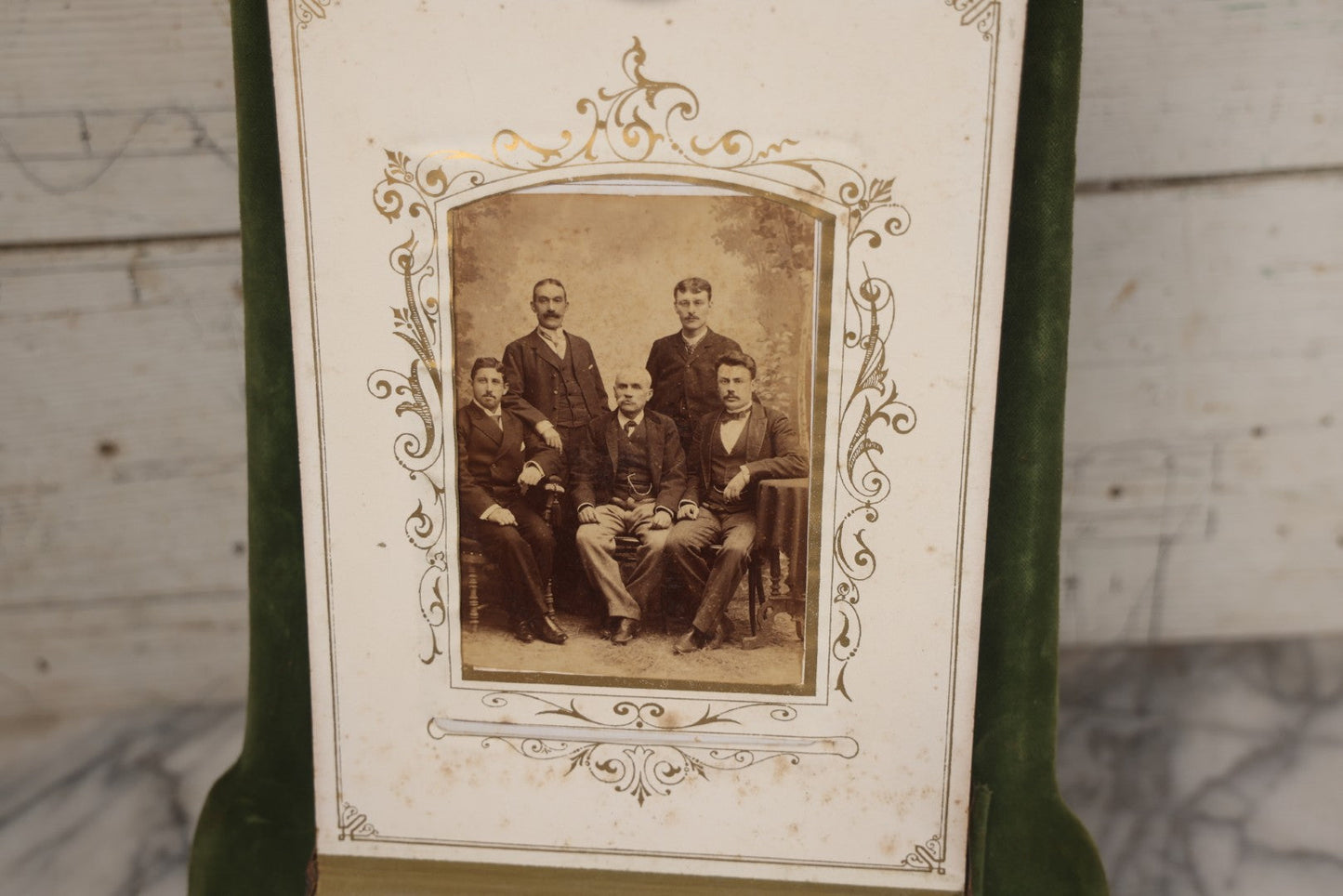 Lot 010 - Antique Victorian Green Velvet Display Photo Album With Stand And Tilt Down Cover, Brass Adornments, Containing 12 Cabinet Card And 24 C.D.V. Photographs And Images, Including Man Posing With Rifle, Sailor In Uniform, And Men Smoking