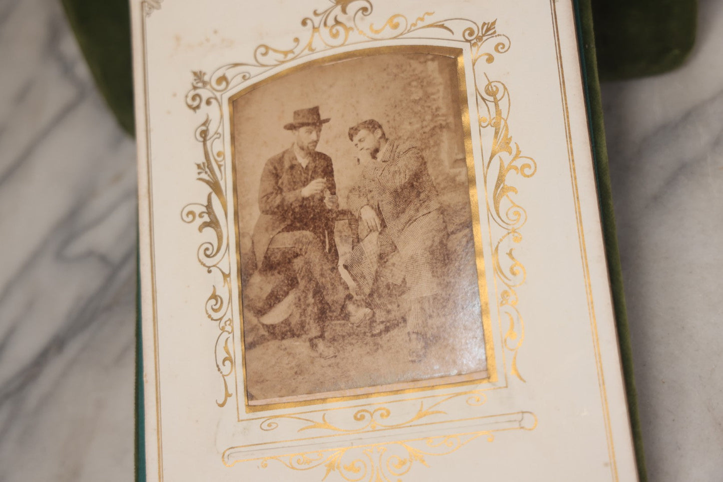 Lot 010 - Antique Victorian Green Velvet Display Photo Album With Stand And Tilt Down Cover, Brass Adornments, Containing 12 Cabinet Card And 24 C.D.V. Photographs And Images, Including Man Posing With Rifle, Sailor In Uniform, And Men Smoking
