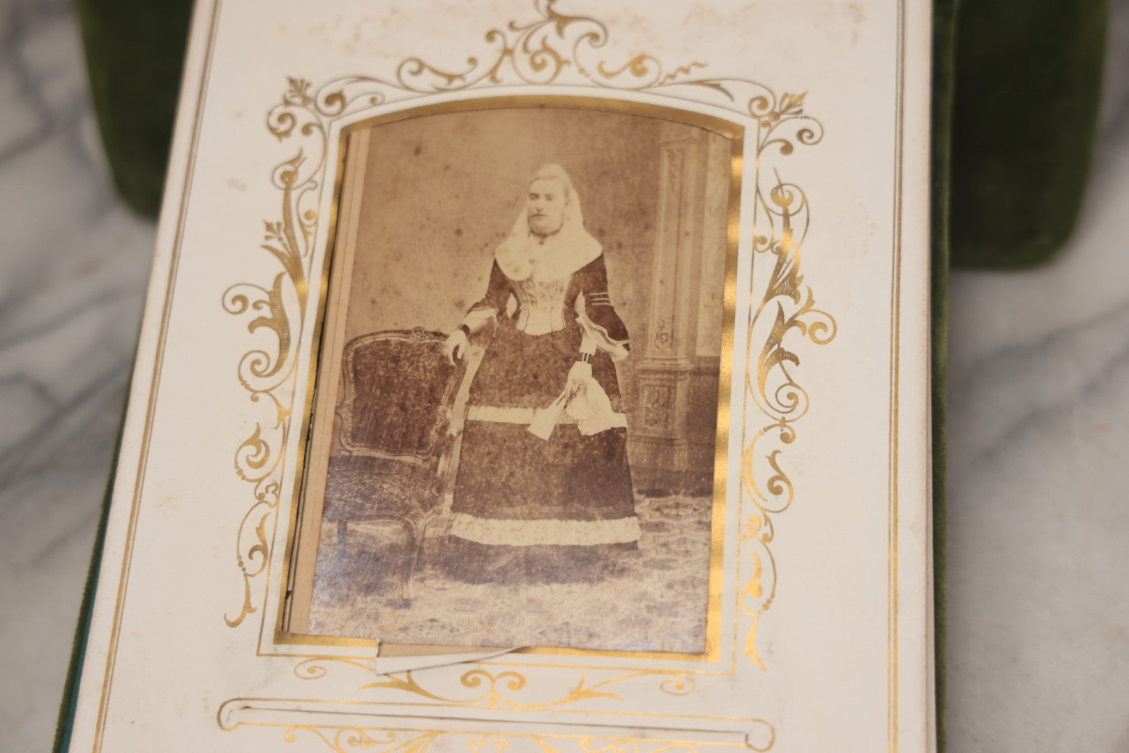 Lot 010 - Antique Victorian Green Velvet Display Photo Album With Stand And Tilt Down Cover, Brass Adornments, Containing 12 Cabinet Card And 24 C.D.V. Photographs And Images, Including Man Posing With Rifle, Sailor In Uniform, And Men Smoking