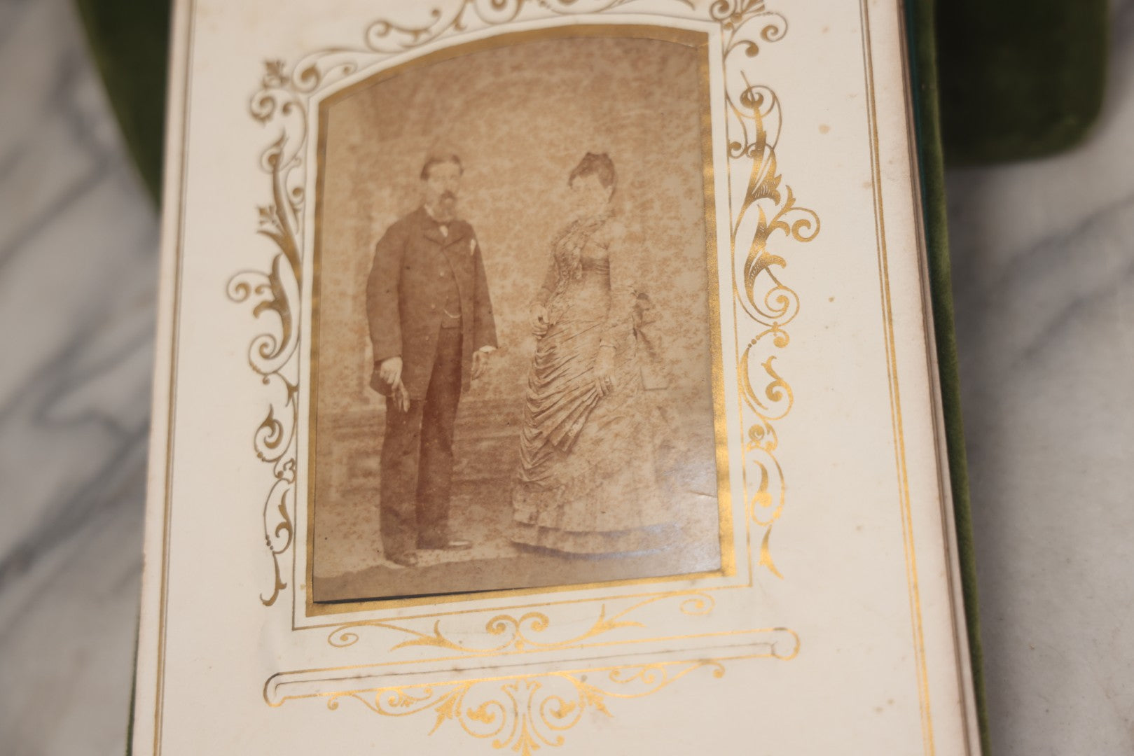 Lot 010 - Antique Victorian Green Velvet Display Photo Album With Stand And Tilt Down Cover, Brass Adornments, Containing 12 Cabinet Card And 24 C.D.V. Photographs And Images, Including Man Posing With Rifle, Sailor In Uniform, And Men Smoking