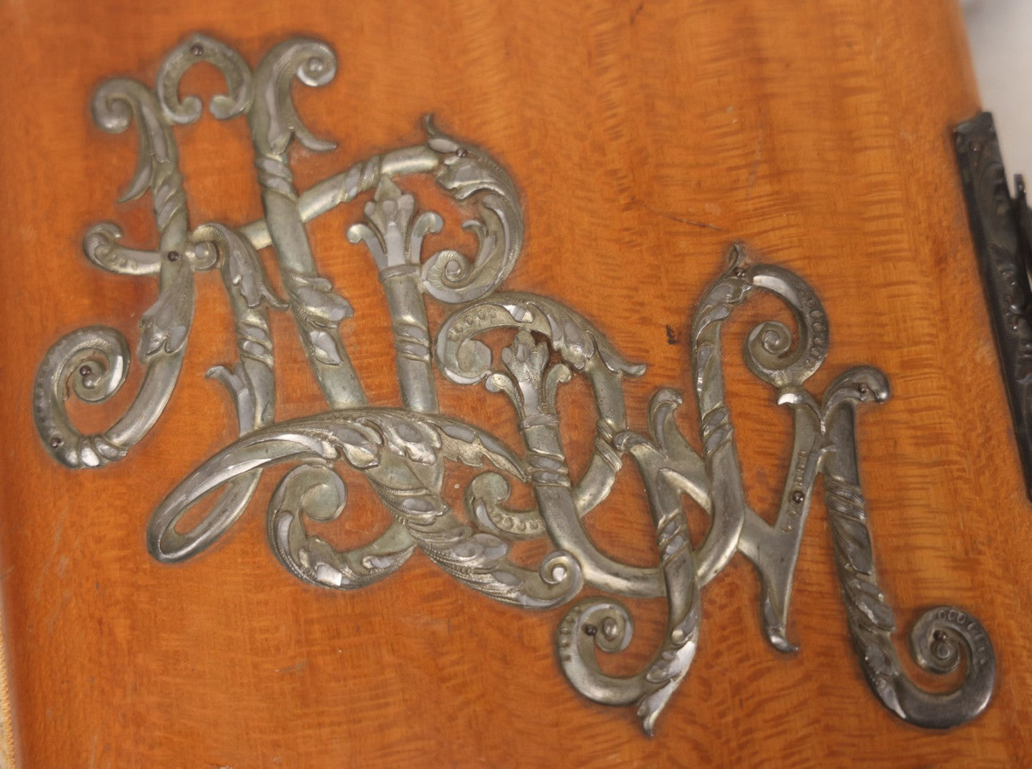 Lot 012 - Antique Victorian Photo Album With Wood Cover And Silverplate Emblem, Containing Twenty Antique Photographs Of Various Types, Including Man In Office, Children With Pram, Man With White Beard, Note Binding Wear Cover Loosening