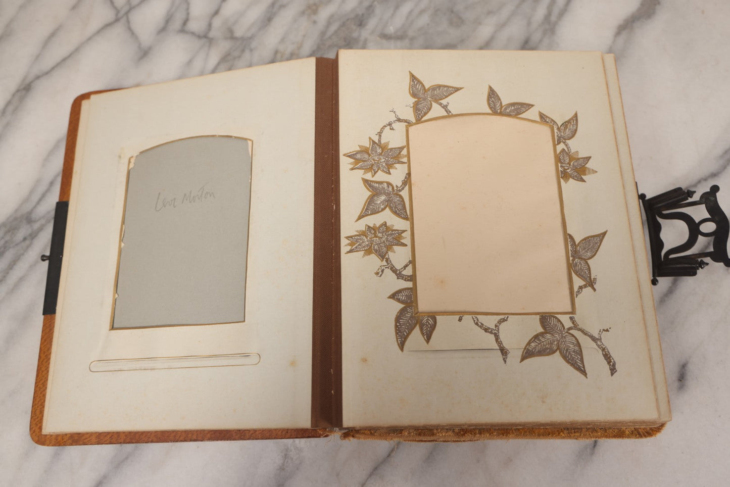 Lot 012 - Antique Victorian Photo Album With Wood Cover And Silverplate Emblem, Containing Twenty Antique Photographs Of Various Types, Including Man In Office, Children With Pram, Man With White Beard, Note Binding Wear Cover Loosening