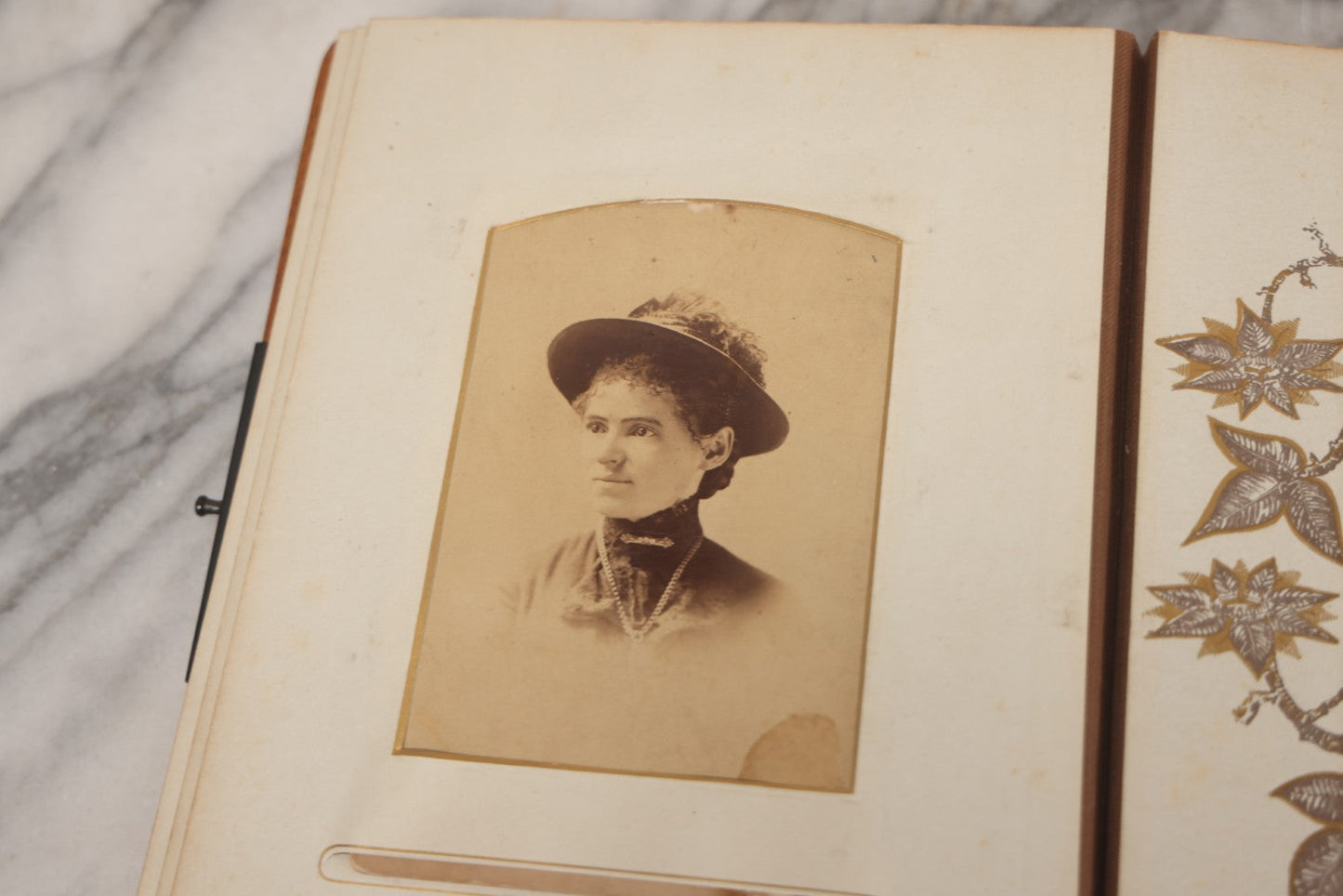 Lot 012 - Antique Victorian Photo Album With Wood Cover And Silverplate Emblem, Containing Twenty Antique Photographs Of Various Types, Including Man In Office, Children With Pram, Man With White Beard, Note Binding Wear Cover Loosening