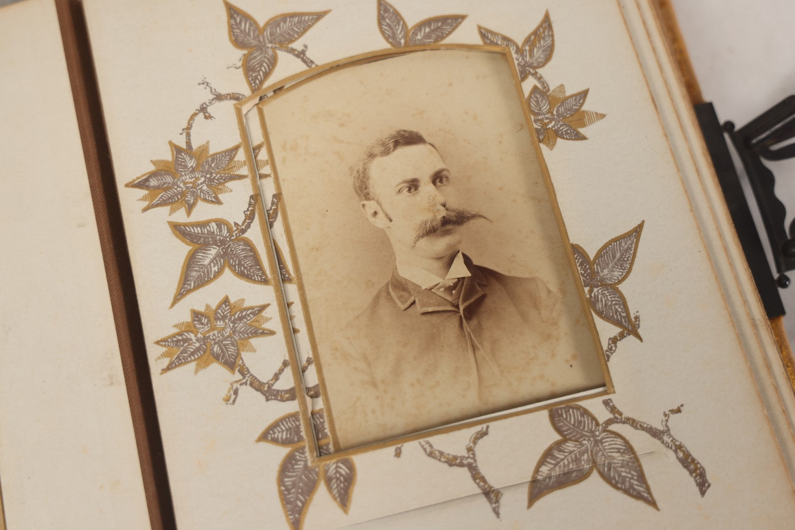 Lot 012 - Antique Victorian Photo Album With Wood Cover And Silverplate Emblem, Containing Twenty Antique Photographs Of Various Types, Including Man In Office, Children With Pram, Man With White Beard, Note Binding Wear Cover Loosening