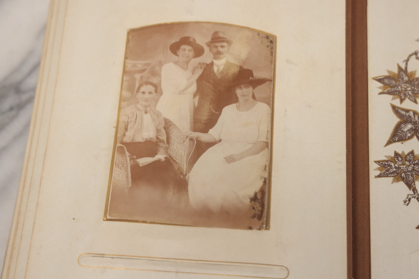 Lot 012 - Antique Victorian Photo Album With Wood Cover And Silverplate Emblem, Containing Twenty Antique Photographs Of Various Types, Including Man In Office, Children With Pram, Man With White Beard, Note Binding Wear Cover Loosening