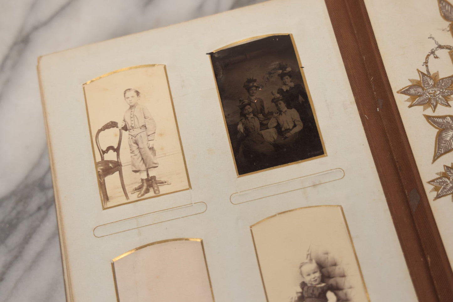 Lot 012 - Antique Victorian Photo Album With Wood Cover And Silverplate Emblem, Containing Twenty Antique Photographs Of Various Types, Including Man In Office, Children With Pram, Man With White Beard, Note Binding Wear Cover Loosening