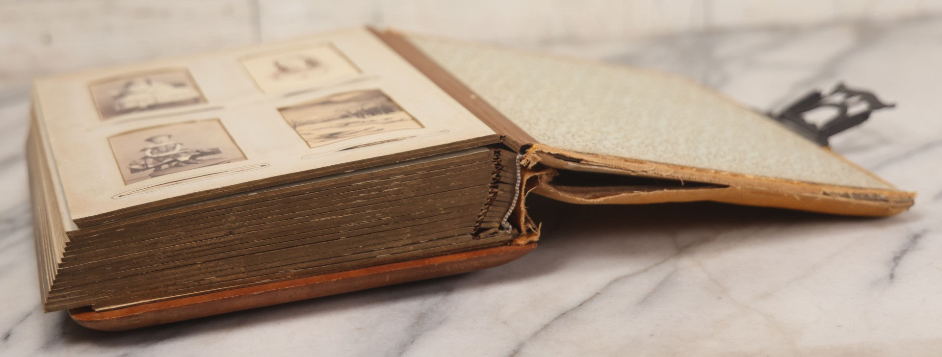 Lot 012 - Antique Victorian Photo Album With Wood Cover And Silverplate Emblem, Containing Twenty Antique Photographs Of Various Types, Including Man In Office, Children With Pram, Man With White Beard, Note Binding Wear Cover Loosening