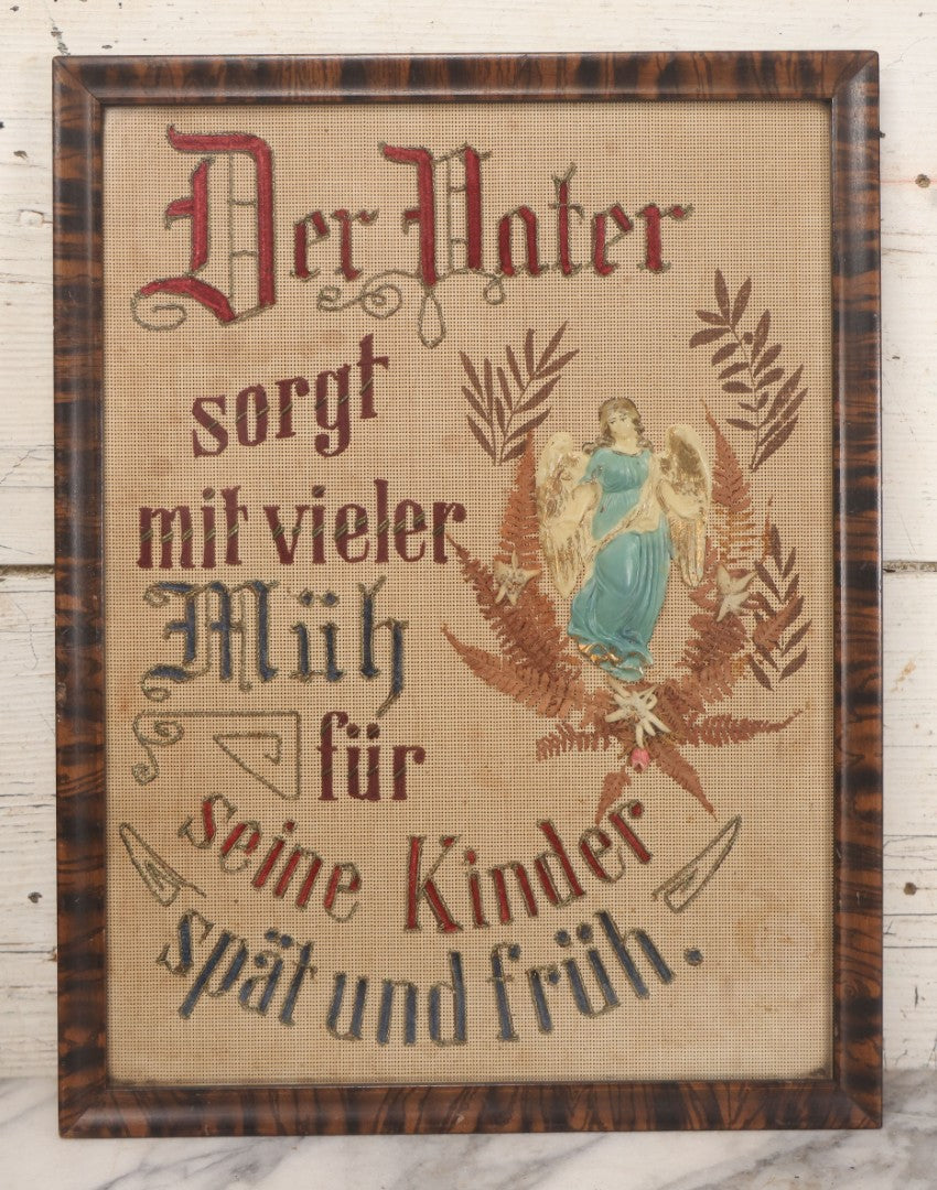Lot 021 - Antique German Paper Punch Needlework Embroidery Motto, Translates To "The Father Cares With Much Effort For His Children, Late And Early" With Celluloid Angel Figure And Pressed Ferns, In Frame, 12-7/8" x 16-7/8"