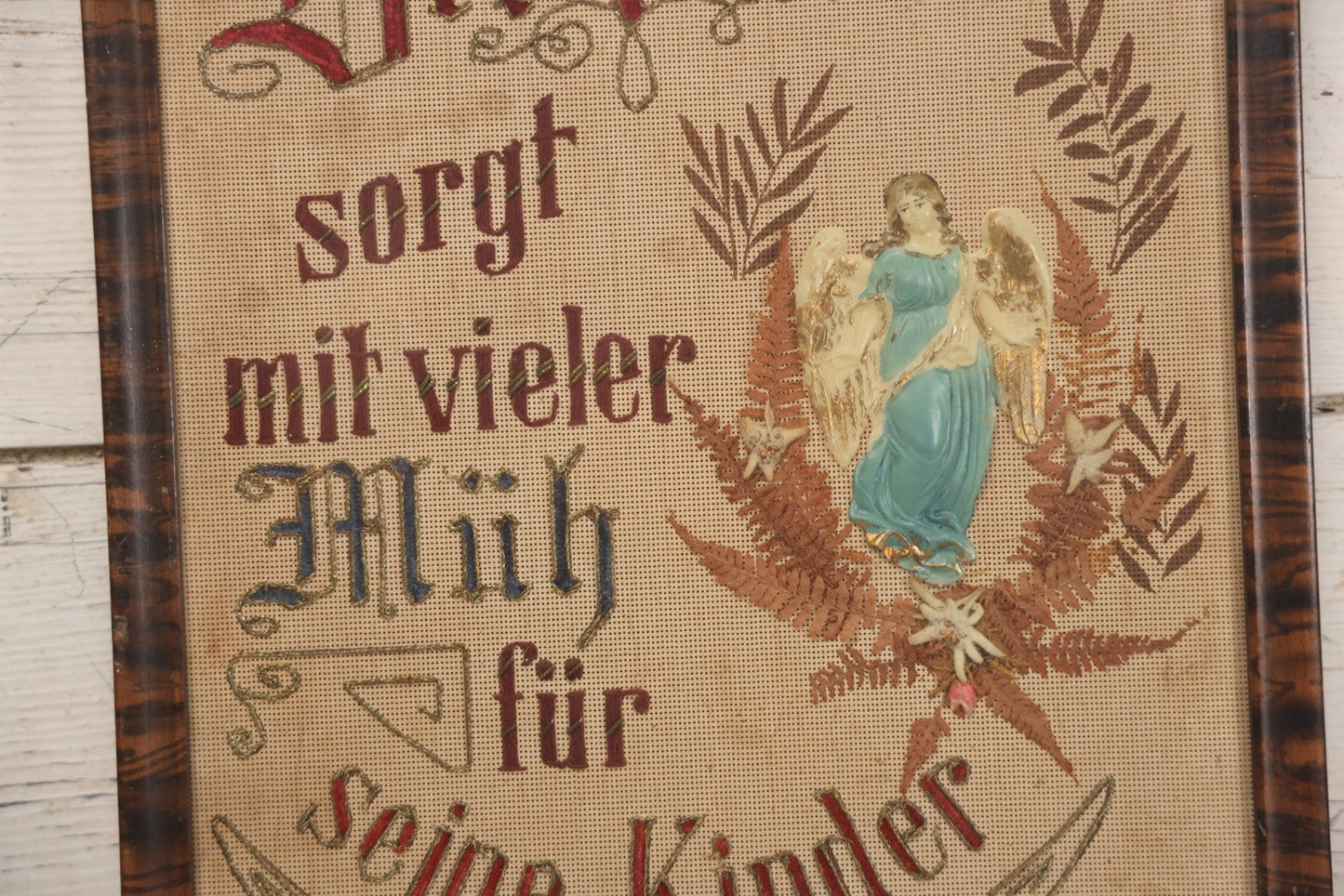 Lot 021 - Antique German Paper Punch Needlework Embroidery Motto, Translates To "The Father Cares With Much Effort For His Children, Late And Early" With Celluloid Angel Figure And Pressed Ferns, In Frame, 12-7/8" x 16-7/8"