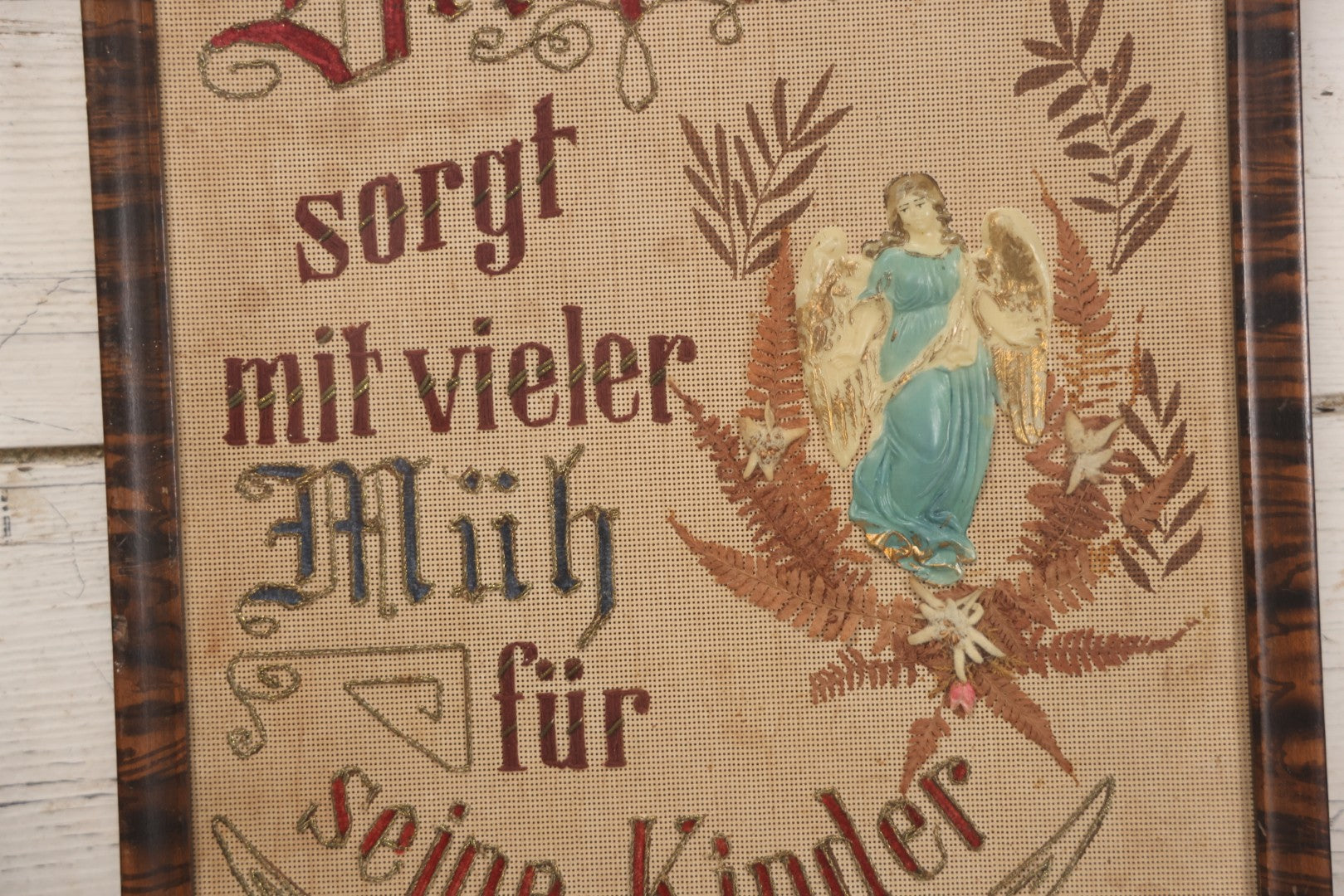 Lot 021 - Antique German Paper Punch Needlework Embroidery Motto, Translates To "The Father Cares With Much Effort For His Children, Late And Early" With Celluloid Angel Figure And Pressed Ferns, In Frame, 12-7/8" x 16-7/8"