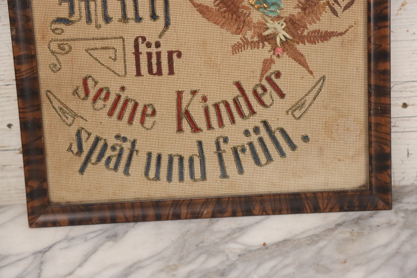 Lot 021 - Antique German Paper Punch Needlework Embroidery Motto, Translates To "The Father Cares With Much Effort For His Children, Late And Early" With Celluloid Angel Figure And Pressed Ferns, In Frame, 12-7/8" x 16-7/8"