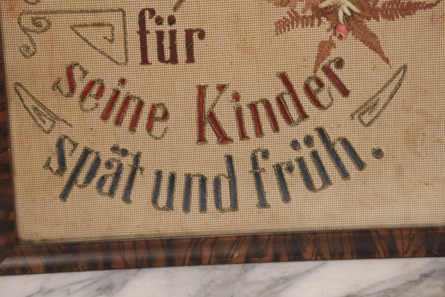 Lot 021 - Antique German Paper Punch Needlework Embroidery Motto, Translates To "The Father Cares With Much Effort For His Children, Late And Early" With Celluloid Angel Figure And Pressed Ferns, In Frame, 12-7/8" x 16-7/8"