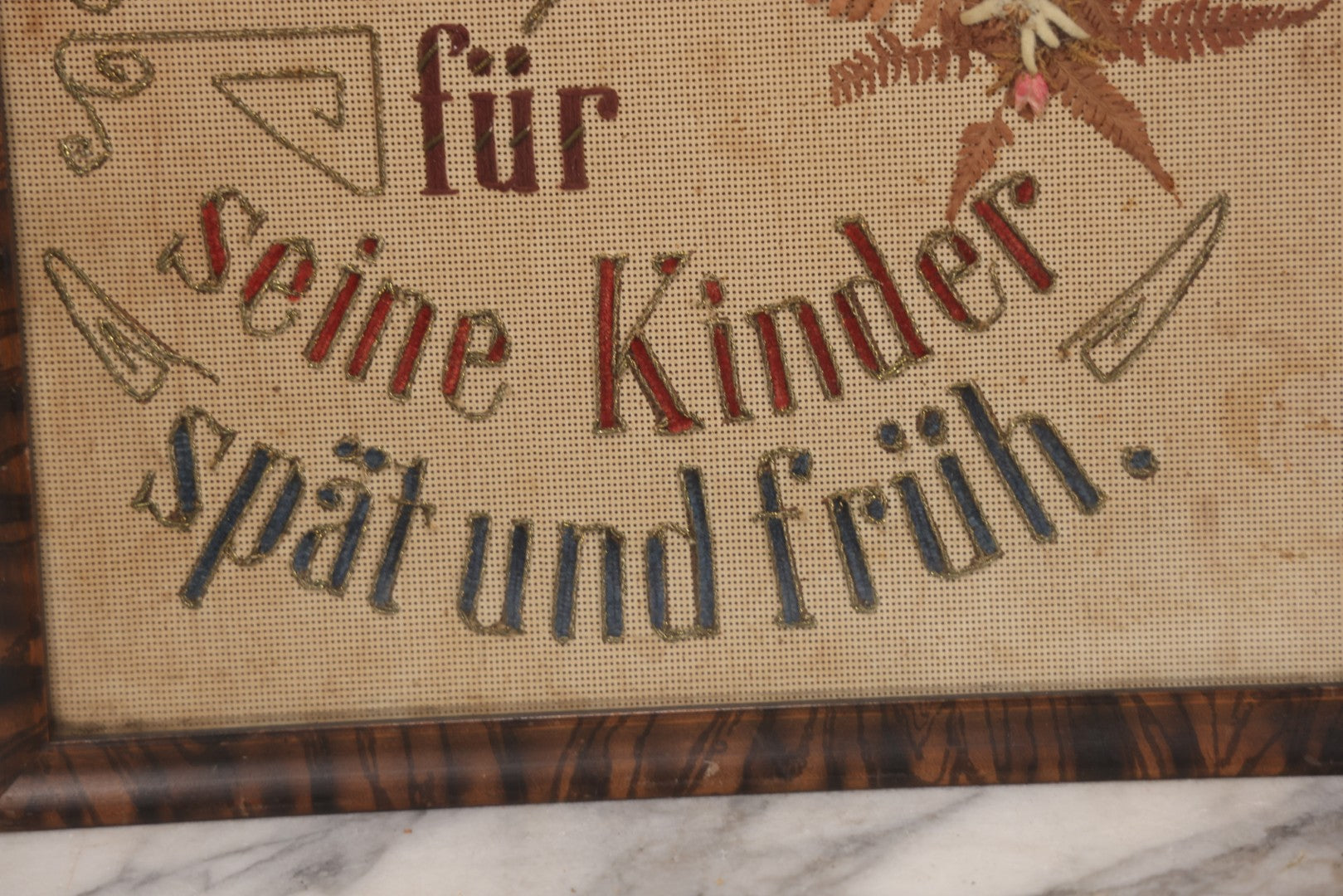Lot 021 - Antique German Paper Punch Needlework Embroidery Motto, Translates To "The Father Cares With Much Effort For His Children, Late And Early" With Celluloid Angel Figure And Pressed Ferns, In Frame, 12-7/8" x 16-7/8"