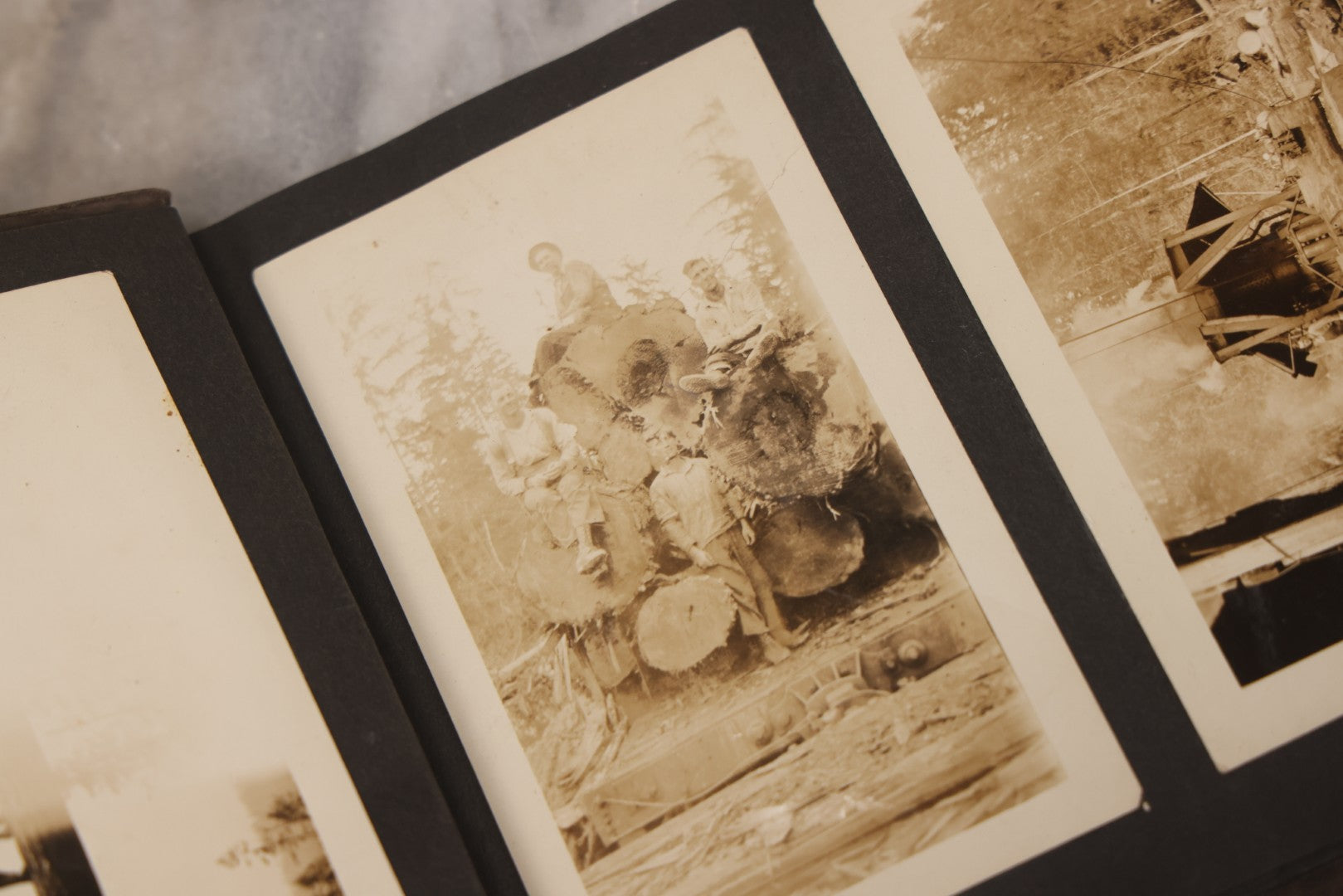 Lot 031 - Vintage Snapshot Photo Album With 46 Snapshot Photographs Including Occupational Photos Of Loggers At Work, Photos Of Children, Mountains, Rivers, And Other Vernacular Photos, Circa 1920s