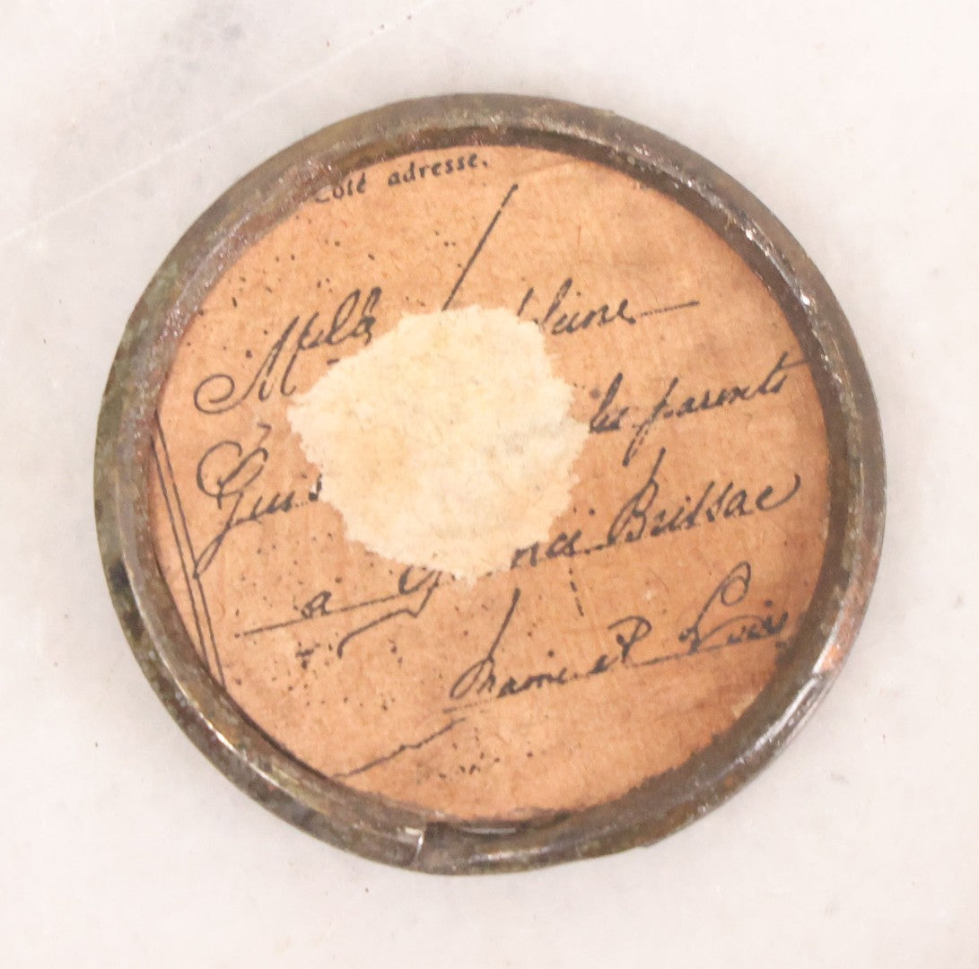 Lot 070 - Antique Painted Tintype Of Woman, Key Ring Souvenir, With Paper Identification In French On Verso, Illegible Due To Paper Loss, 1-1/2" Diameter
