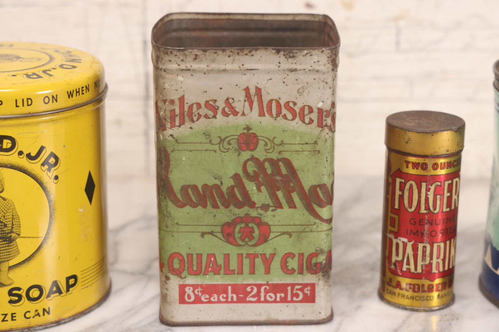 Lot 075 - Four Piece Vintage Tin Grouping Including Bugler Cigarette Tobacco, Niles & Moser's Handmade Quality Cigars, Folger's Paprika, And John D. Jr. Hand Soap