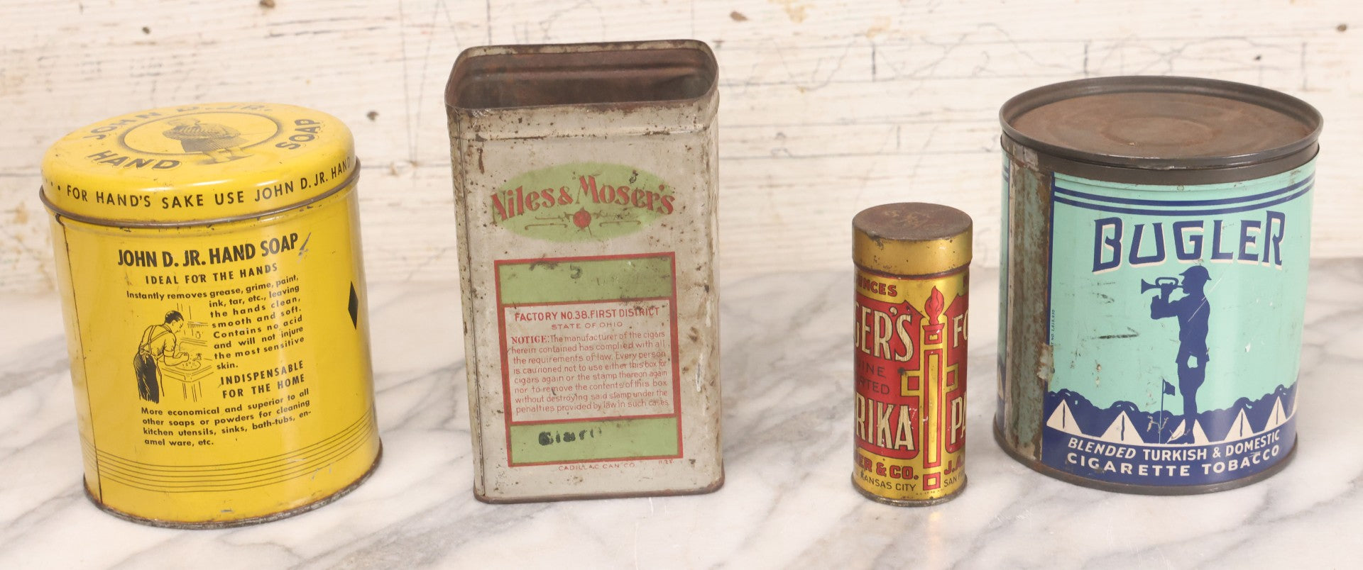 Lot 075 - Four Piece Vintage Tin Grouping Including Bugler Cigarette Tobacco, Niles & Moser's Handmade Quality Cigars, Folger's Paprika, And John D. Jr. Hand Soap