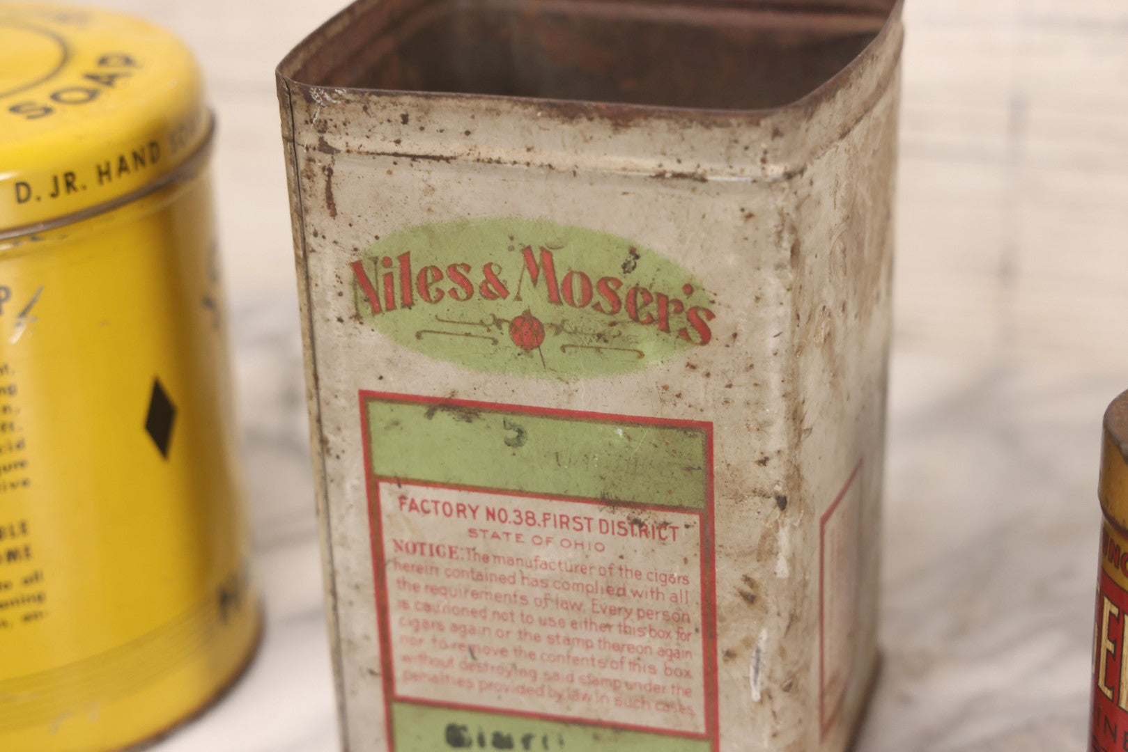 Lot 075 - Four Piece Vintage Tin Grouping Including Bugler Cigarette Tobacco, Niles & Moser's Handmade Quality Cigars, Folger's Paprika, And John D. Jr. Hand Soap