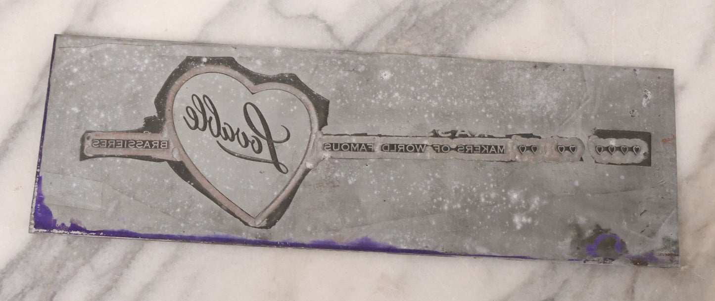 Lot 077 - Grouping Of Four Vintage Metal Printing Plates Including Loveable Brassieres, Surgeons & Physicians Supply Co., Jaw Teasers, And Fragile Stamp